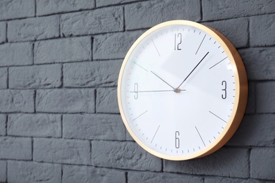 Photo of Modern clock on brick wall. Time concept