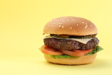 Photo of Burger with delicious patty on yellow background. Space for text