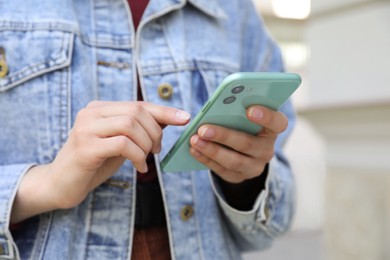 Closeup view of woman using smartphone outdoors