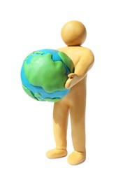 Photo of Yellow plasticine human figure holding planet isolated on white
