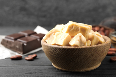 Photo of Organic cocoa butter on black wooden table, closeup