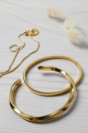 Photo of Beautiful bracelets and necklace on white wooden table, closeup