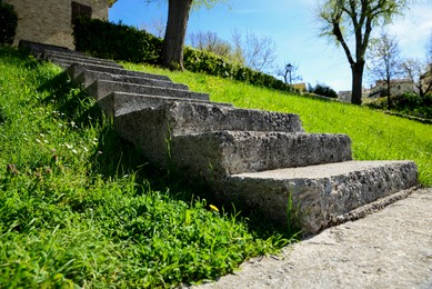 Photo of Stone stairs and green grass outdoors on sunny day, closeup