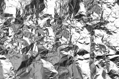 Photo of Crumpled silver foil as background, closeup view