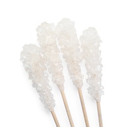 Photo of Wooden sticks with sugar crystals isolated on white, top view. Tasty rock candies