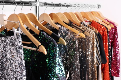 Photo of Collection of different beautiful women's party dresses on hangers in showroom. Stylish trendy clothes for high school prom
