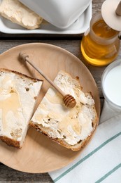 Photo of Slices of bread with butter, honey and milk on wooden table, flat lay