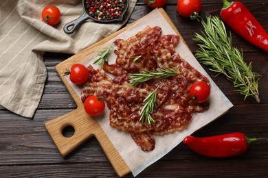 Photo of Slices of tasty fried bacon, tomatoes and different spices on wooden table, top view