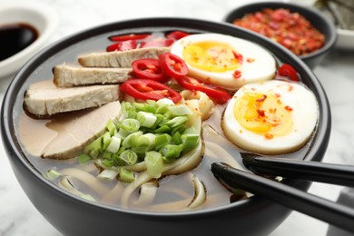 Photo of Delicious ramen in bowl on table, closeup. Noodle soup