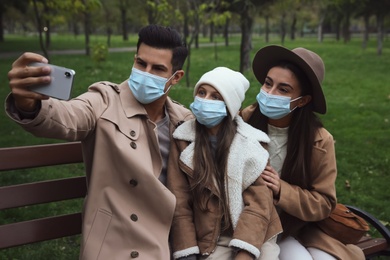 Lovely family taking selfie together in park during coronavirus pandemic