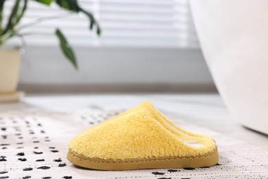Photo of Yellow soft slippers on carpet at home, closeup
