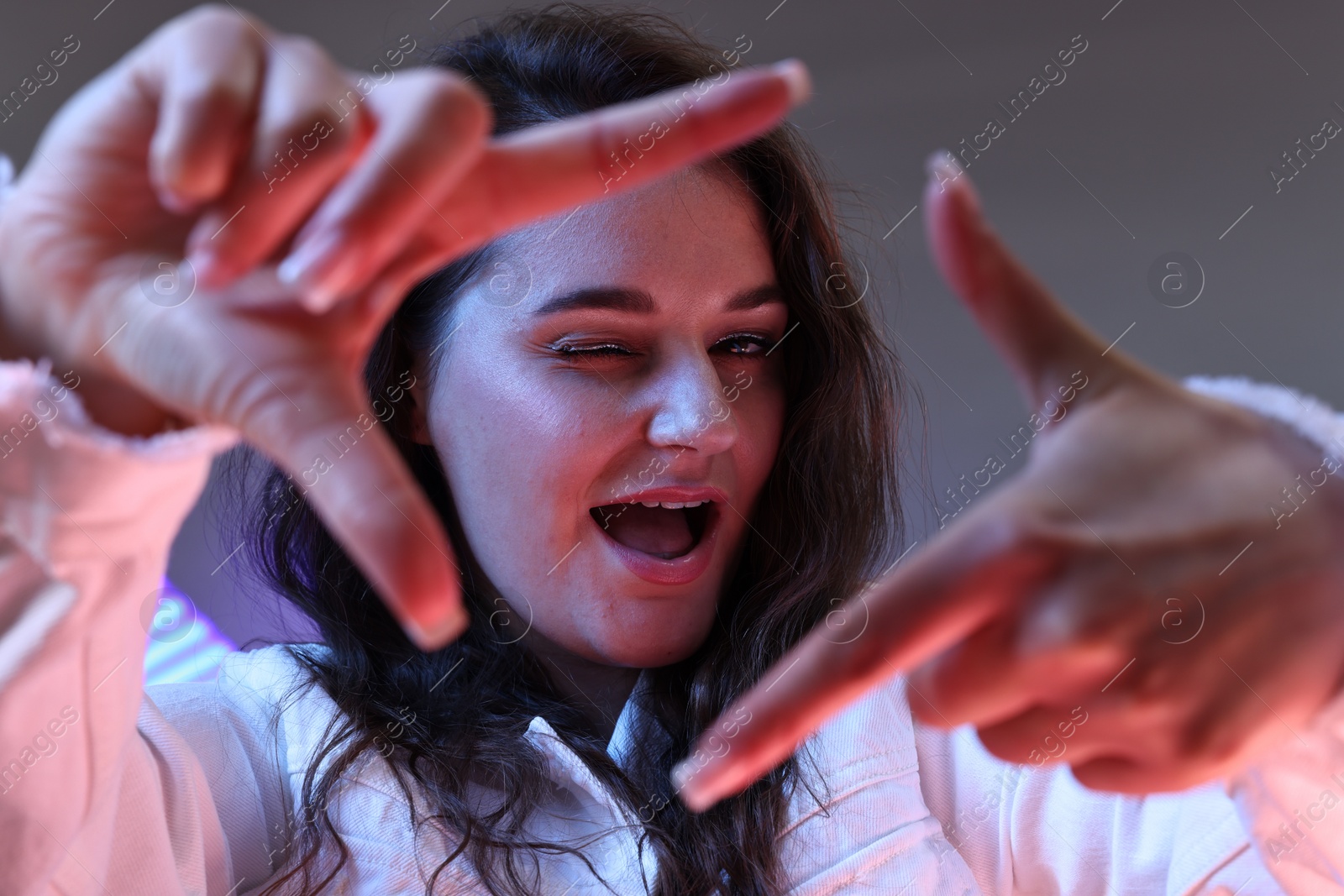 Photo of Portrait of beautiful young woman on color background with neon lights