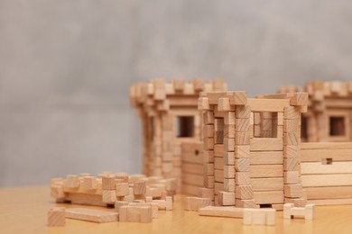 Photo of Wooden fortress and building blocks on table against grey background, space for text. Children's toy