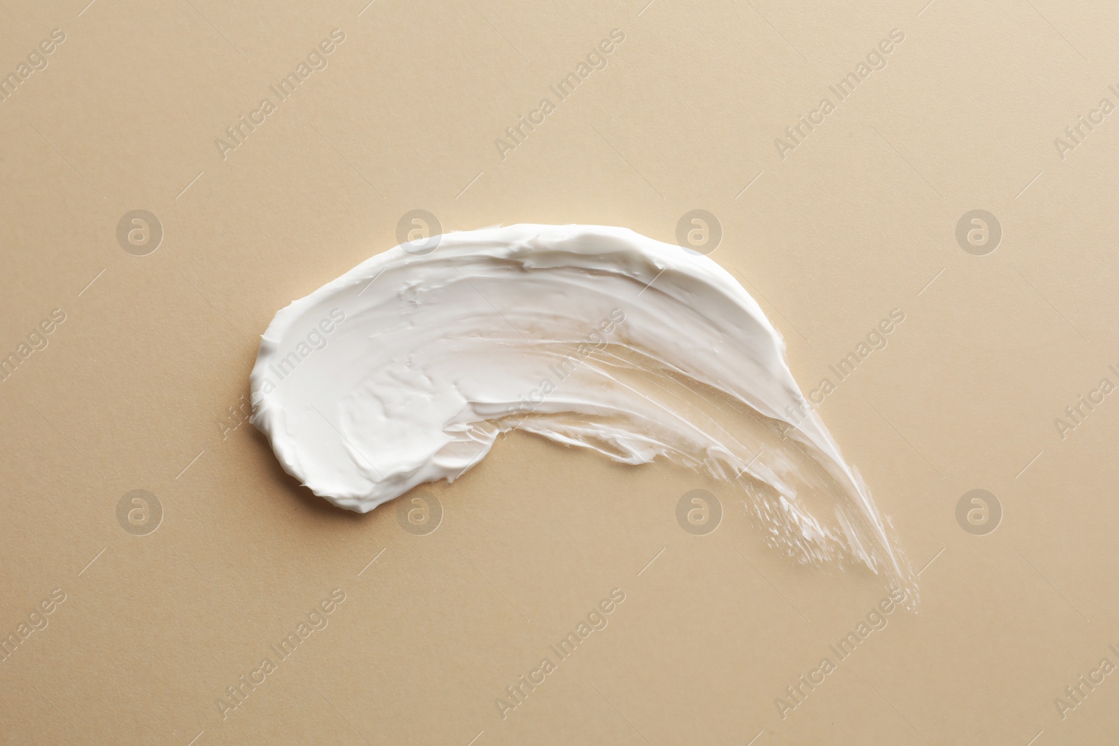 Photo of Sample facial cream on beige background, top view