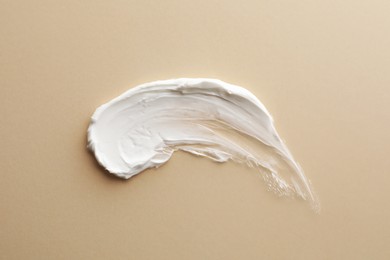 Photo of Sample facial cream on beige background, top view