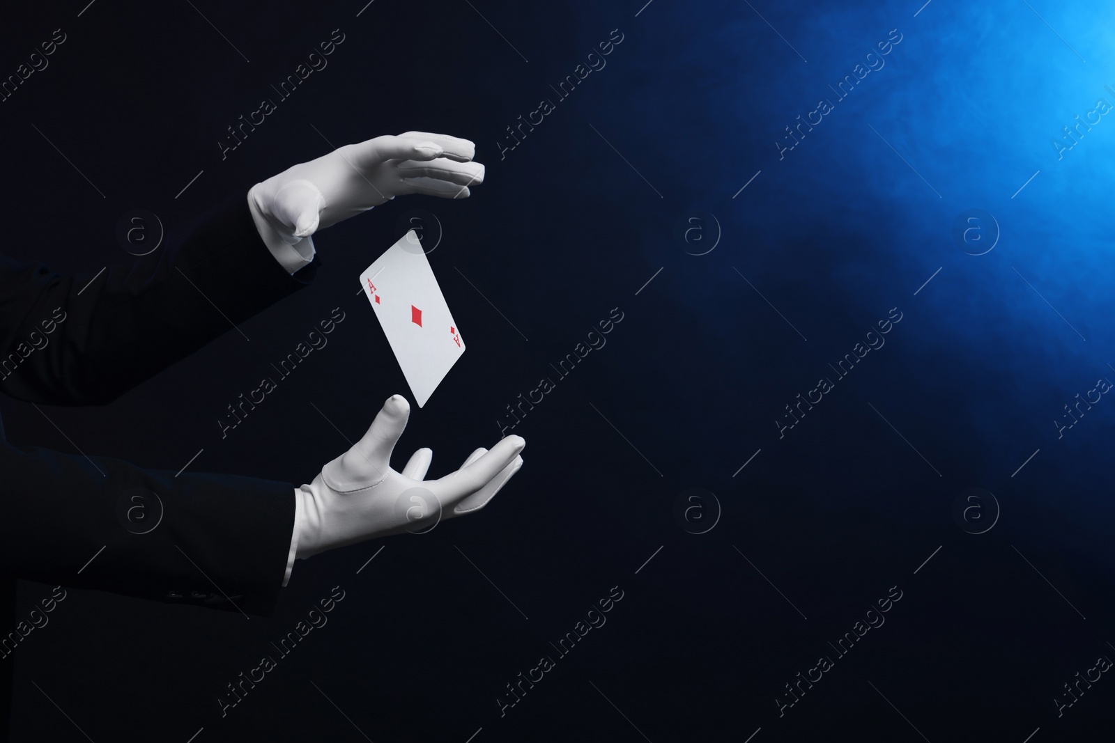 Image of Magician showing trick with card on dark background, closeup. Space for text