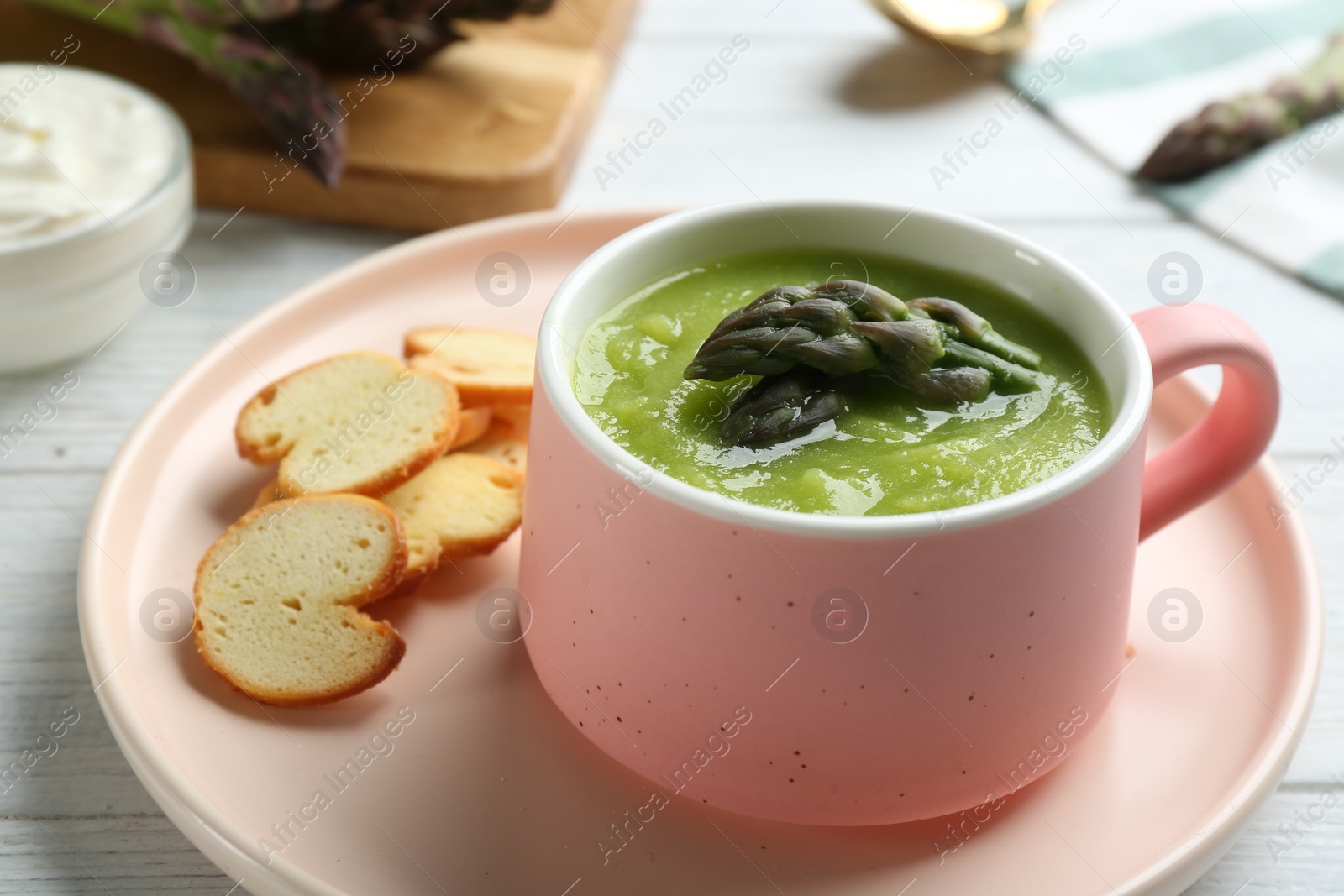 Photo of Delicious asparagus soup served on table, closeup