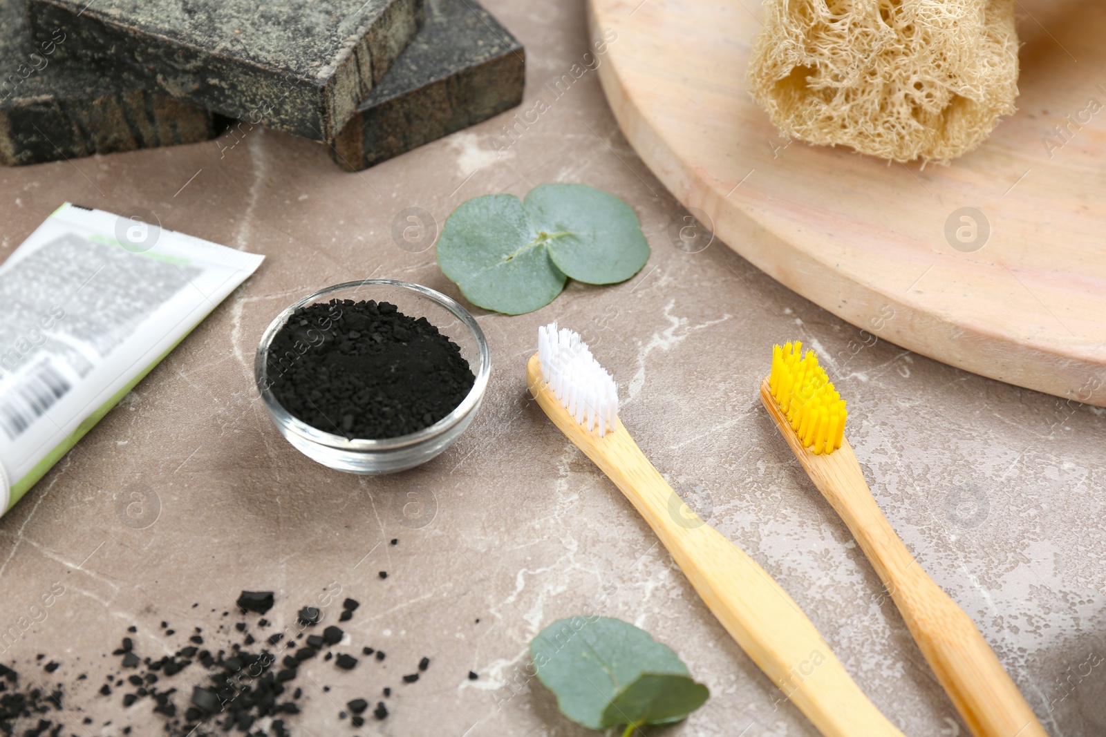 Photo of Composition with bamboo toothbrushes on grey marble table