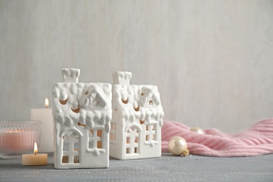 Composition with house shaped candle holders on grey wooden table, space for text. Christmas decoration