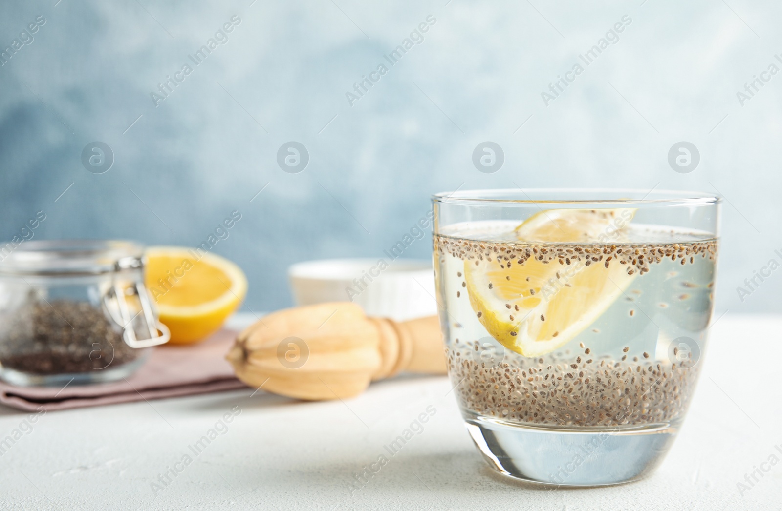 Photo of Composition with glass of water and chia seeds on table against color background. Space for text