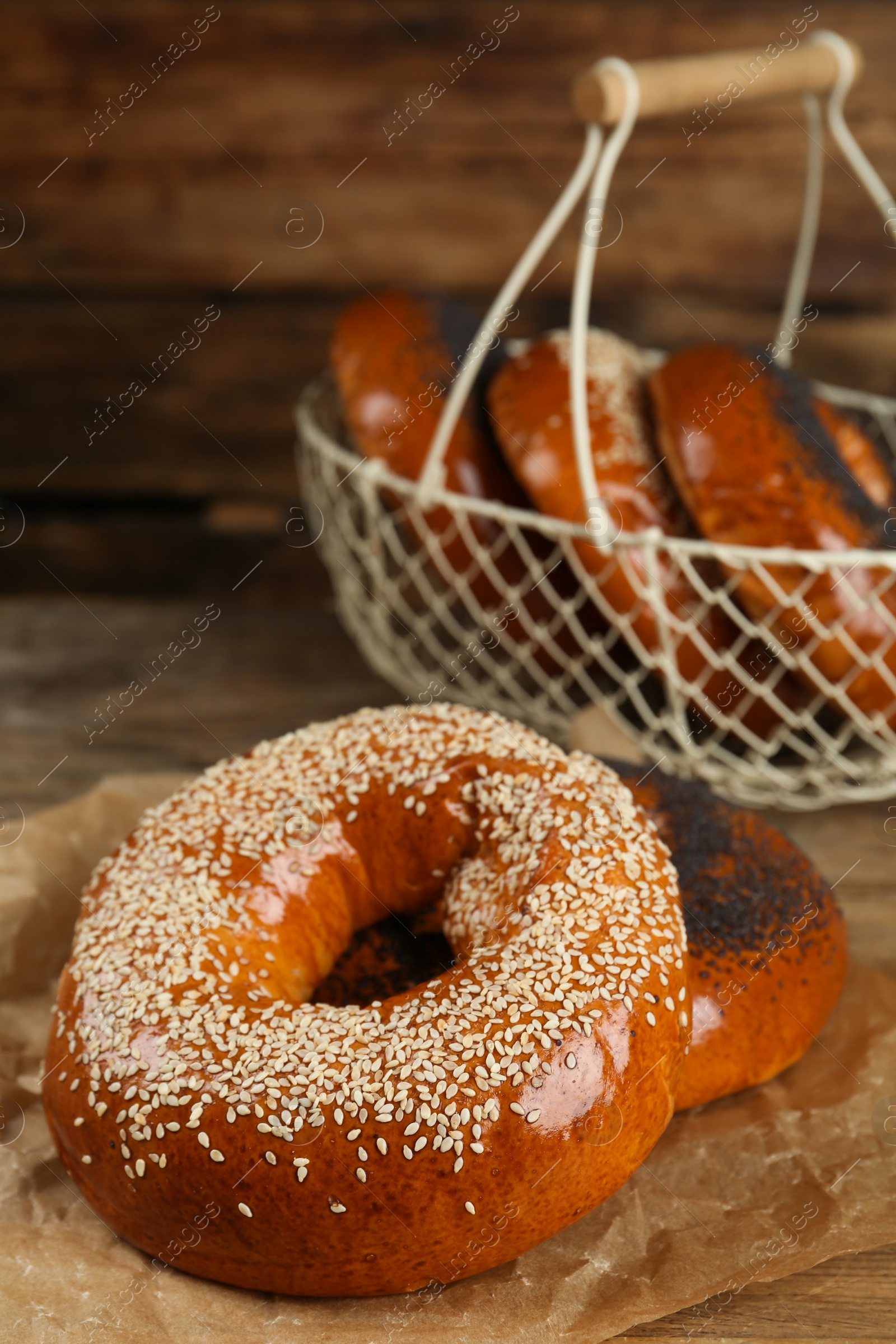 Photo of Delicious fresh bagels with poppy and sesame seeds on wooden table