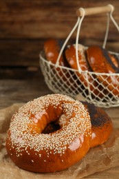 Photo of Delicious fresh bagels with poppy and sesame seeds on wooden table