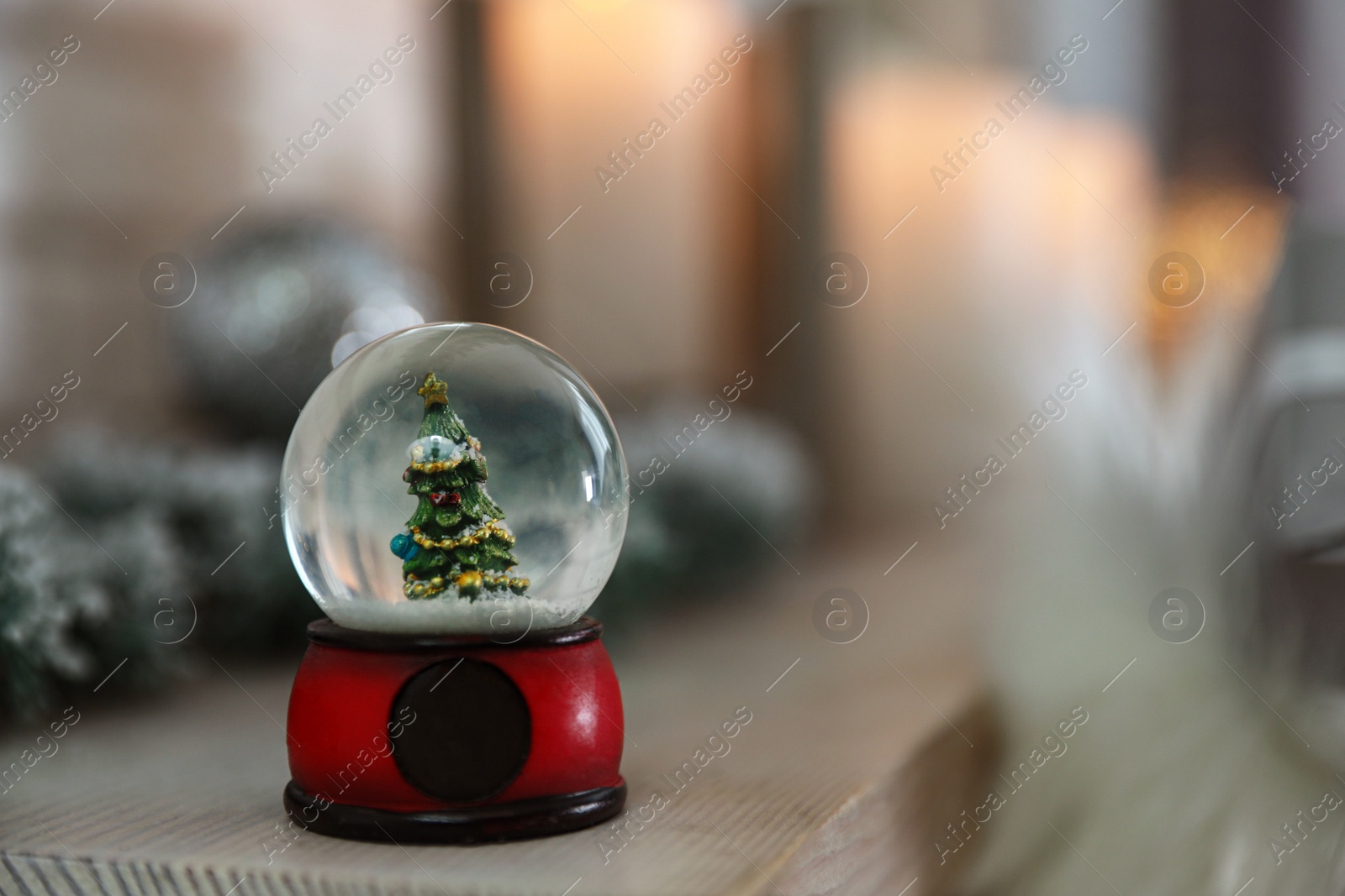 Photo of Snow globe with Christmas tree against blurred background