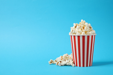 Photo of Delicious popcorn on light blue background. Space for text