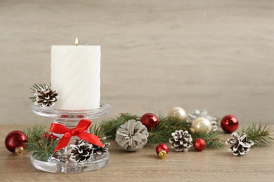 Photo of Christmas composition with glass candlestick and cones on table. Space for text