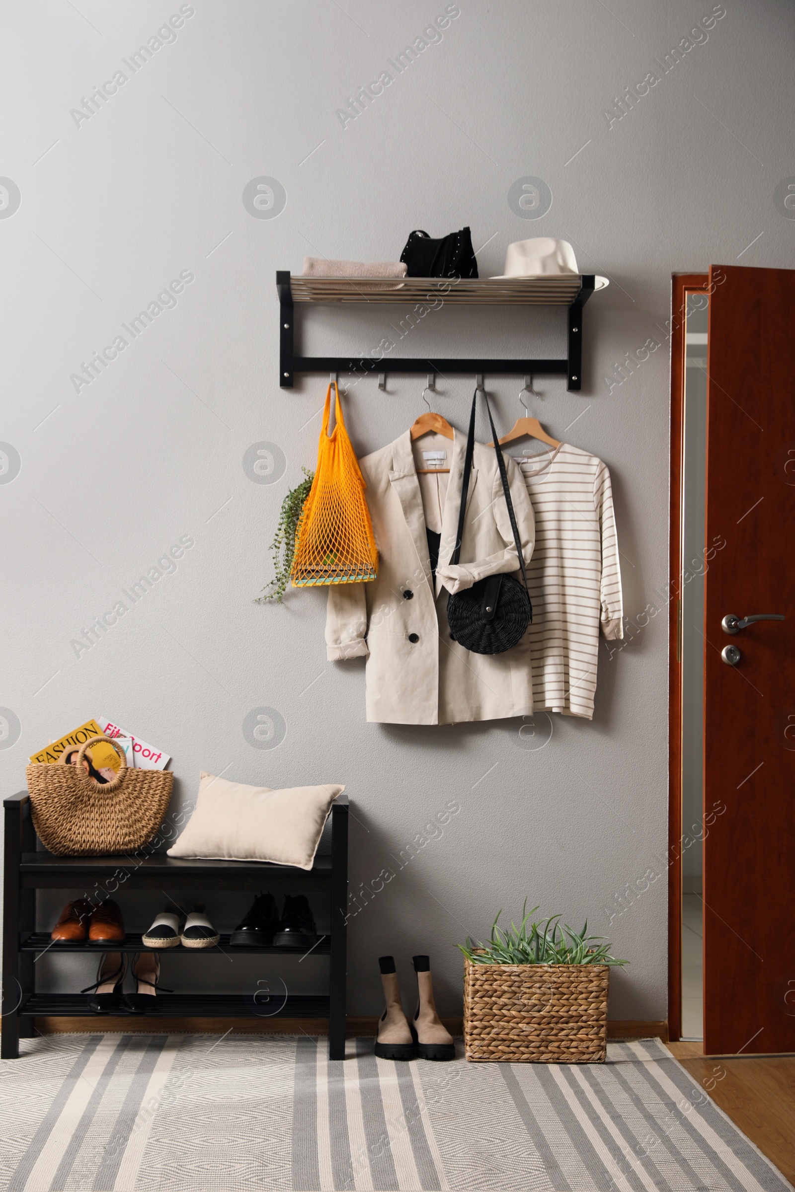 Photo of Hallway interior with stylish furniture, clothes and accessories