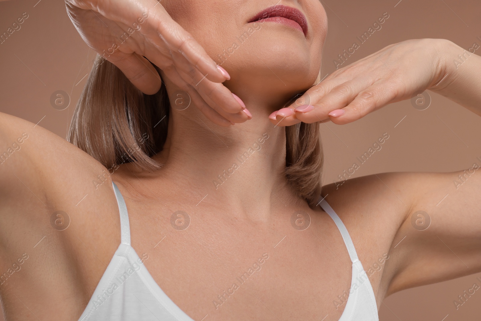 Photo of Woman touching her neck on beige background, closeup