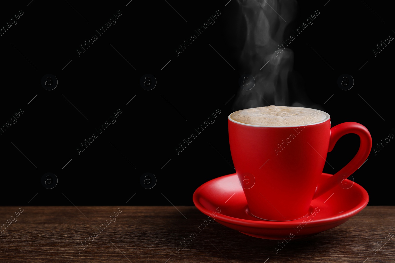 Image of Red cup with hot steaming coffee on wooden table against black background, space for text