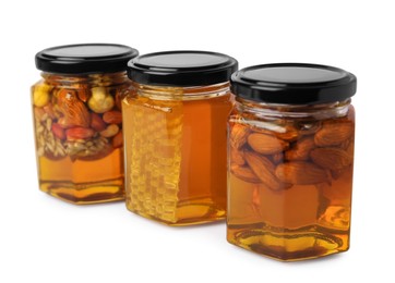 Photo of Jars with different nuts and honey on white background