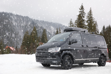 Photo of Black car on snowy road. Winter vacation