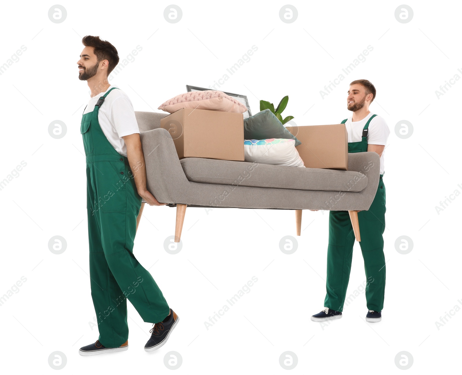 Photo of Young workers carrying sofa with stuff isolated on white. Moving service