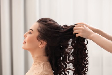 Photo of Hair styling. Professional hairdresser working with client indoors, closeup