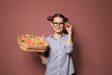 Photo of Attractive young woman with delicious pizza on color background