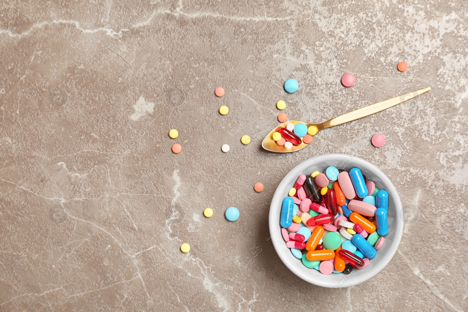 Photo of Bowl and different pills on color background