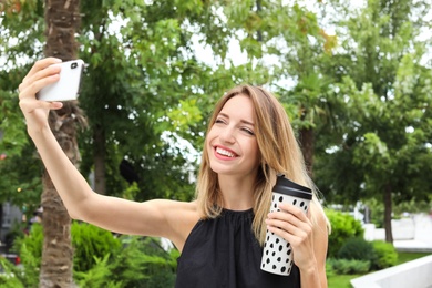 Photo of Attractive woman taking selfie in green park