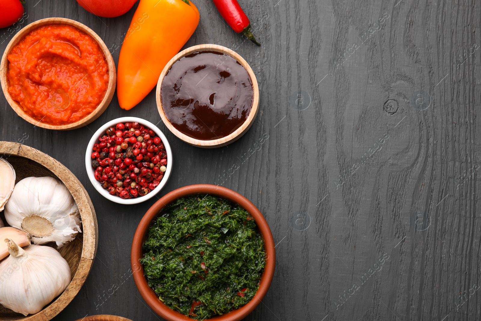 Photo of Different fresh marinades in bowls and ingredients on grey wooden table, flat lay. Space for text