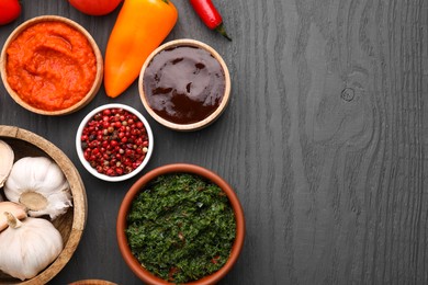 Photo of Different fresh marinades in bowls and ingredients on grey wooden table, flat lay. Space for text