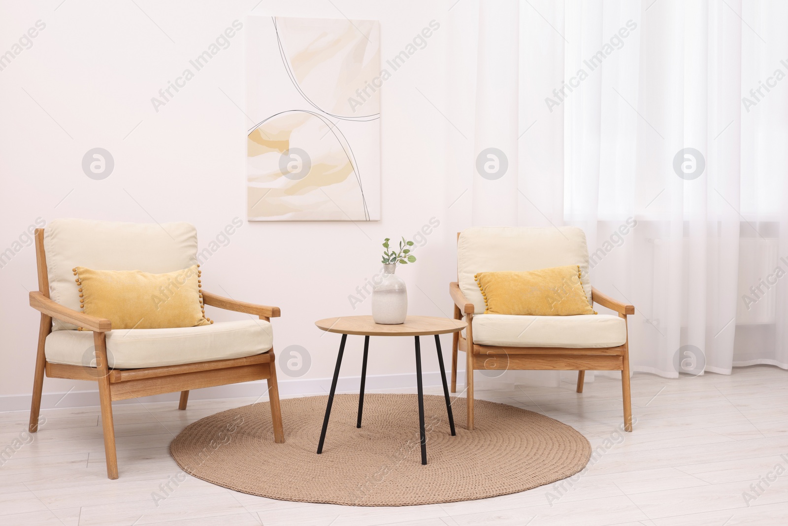 Photo of Stylish armchairs and wooden table in living room. Interior design