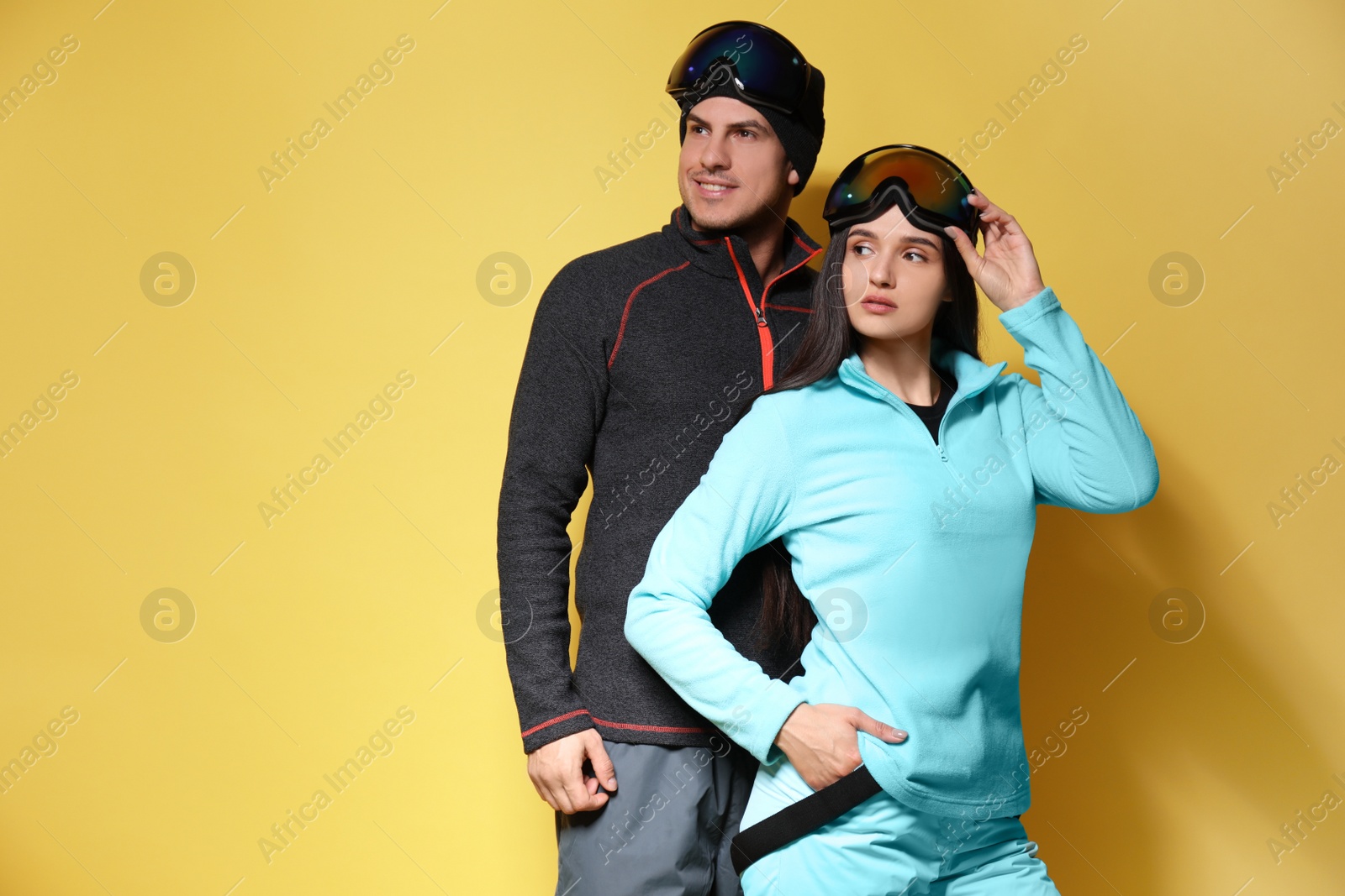 Photo of Couple wearing stylish winter sport clothes on yellow background
