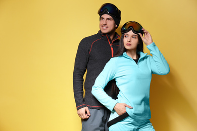 Photo of Couple wearing stylish winter sport clothes on yellow background