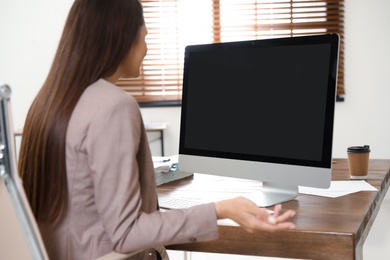 Woman using video chat on computer in home office. Space for text