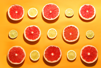 Photo of Flat lay composition with tasty ripe grapefruit slices on orange background