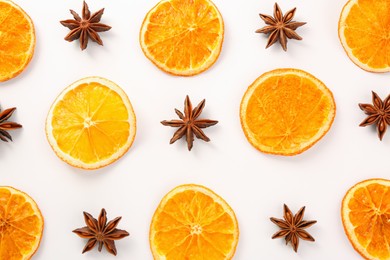 Photo of Dry orange slices and anise stars on white background, flat lay