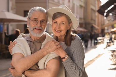 Photo of Affectionate senior couple walking outdoors, space for text