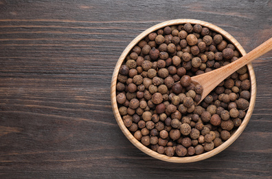 Photo of Peppercorns on wooden table, top view. Space for text