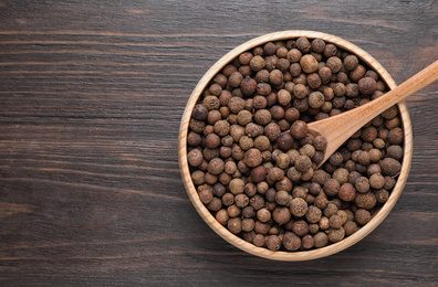 Peppercorns on wooden table, top view. Space for text